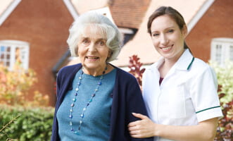 elder woman and caregiver smiling